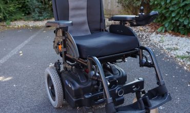 An Invacare Fox powerchair on tarmac.
